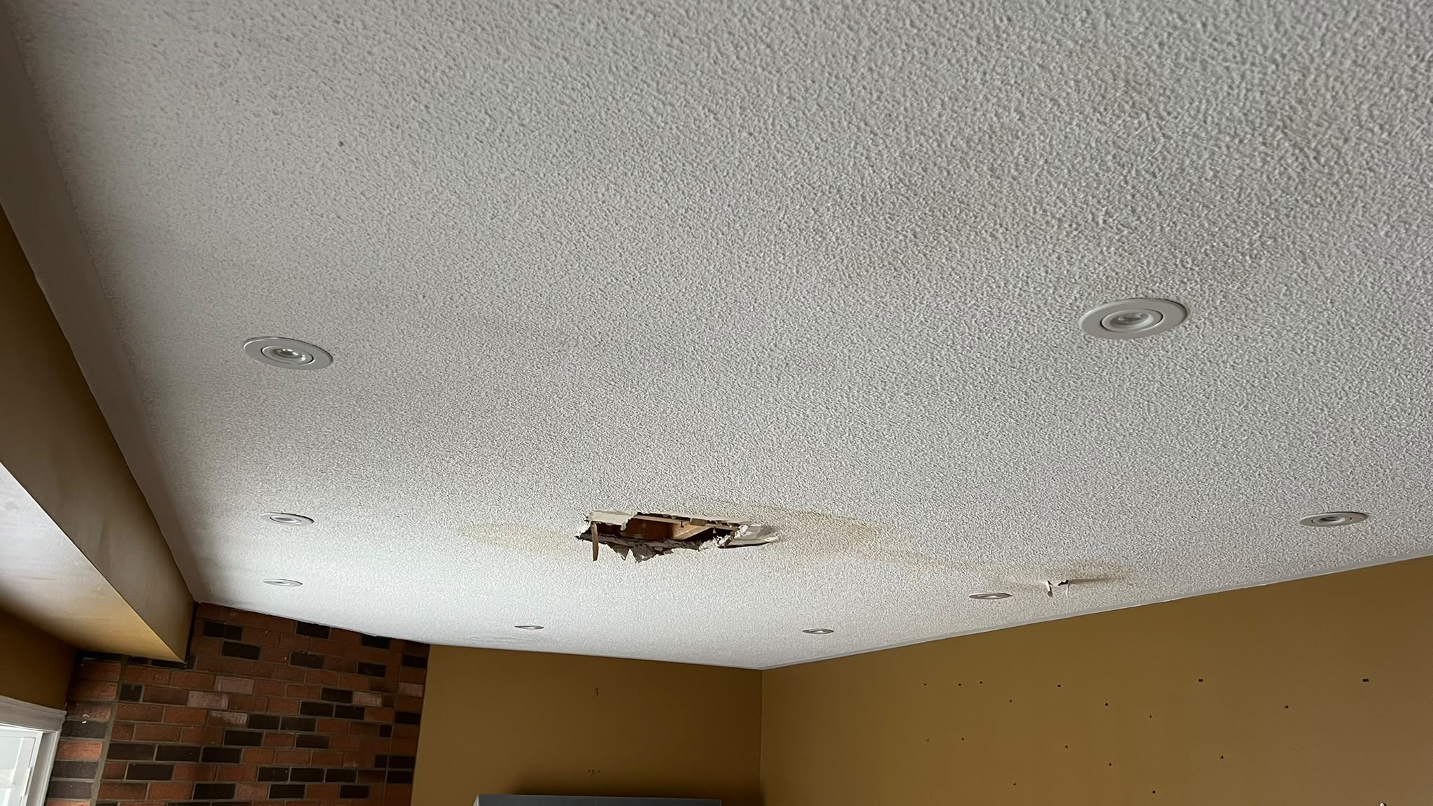 Before: damaged popcorn ceiling with a large hole and cracked surface