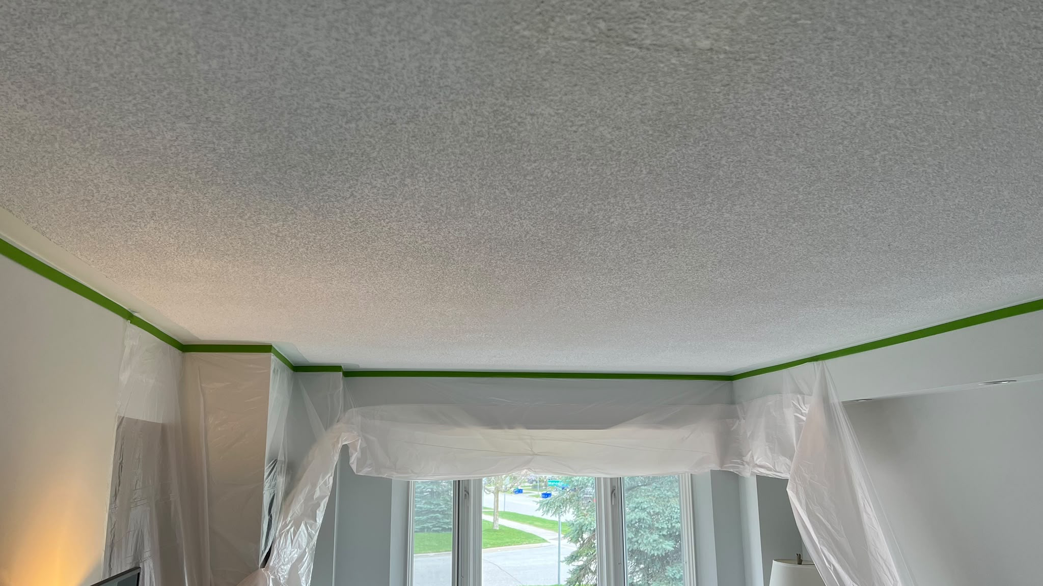 Before: textured popcorn ceiling with walls protected for removal